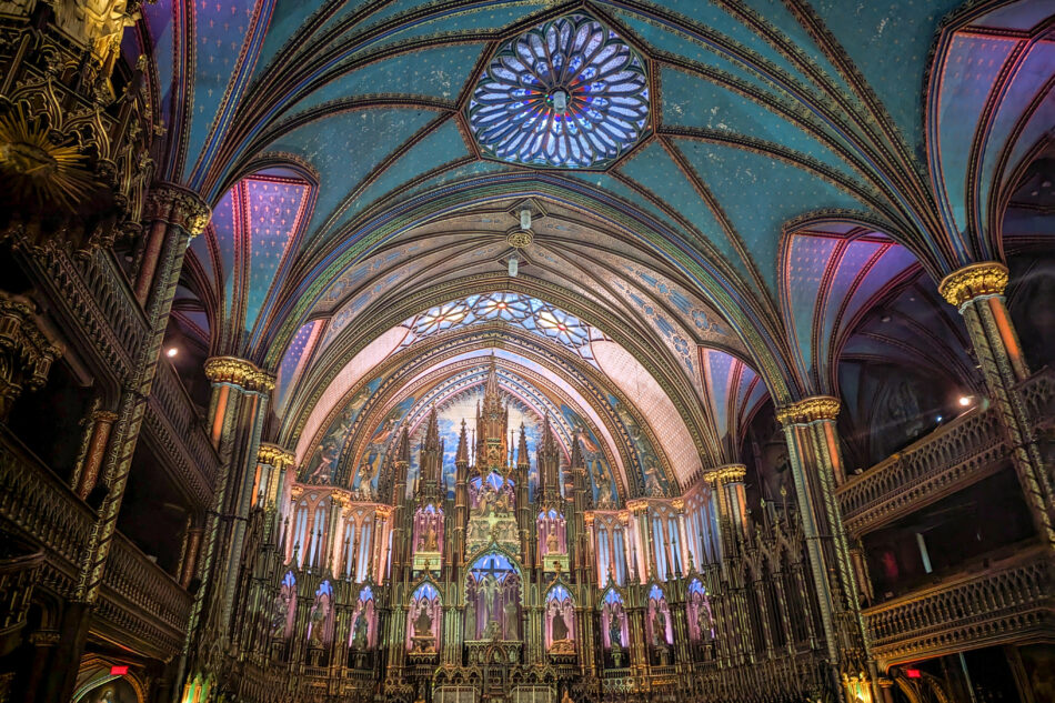 Spectacular view inside Notre-Dame Basilica featuring an illuminated station with vibrant Gothic revival architecture, highlighted by radiant lighting and decorative elements.